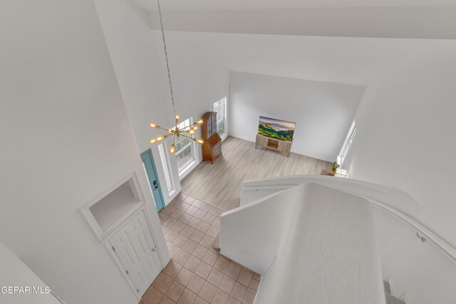 1121 Regal Ridge Dr, El Paso, TX 79912 - stairway featuring tile patterned flooring, a chandelier, and high vaulted ceiling