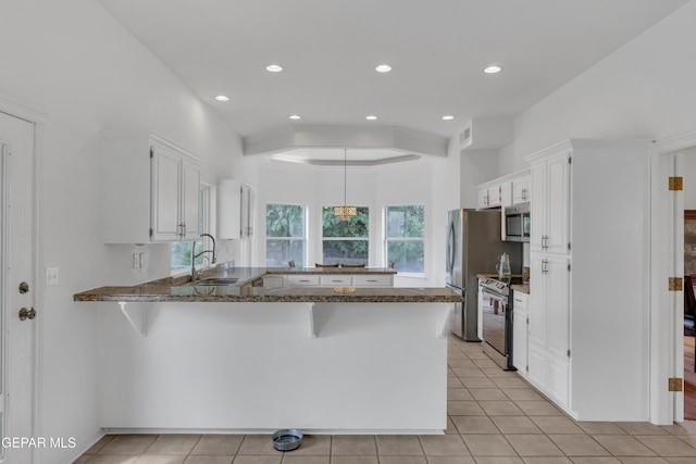 1121 Regal Ridge Dr, El Paso, TX 79912 - kitchen with stainless steel appliances, a peninsula, dark stone countertops, white cabinetry, and recessed lighting