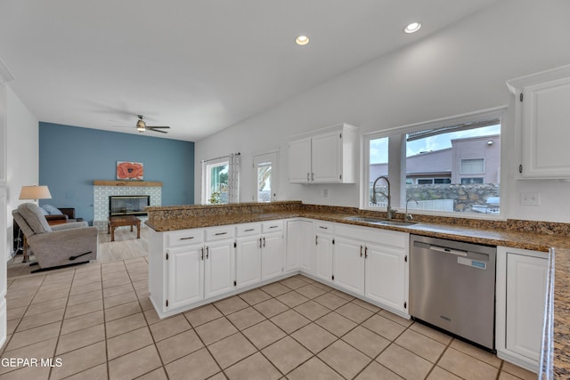 1121 Regal Ridge Dr, El Paso, TX 79912 - kitchen with dishwasher, ceiling fan, light tile patterned floors, a glass covered fireplace, and white cabinetry