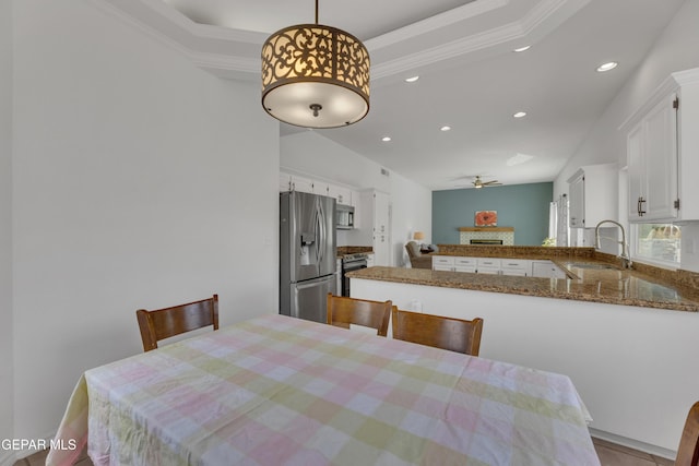 1121 Regal Ridge Dr, El Paso, TX 79912 - dining space featuring a ceiling fan, recessed lighting, a raised ceiling, crown molding, and a fireplace
