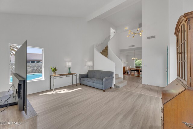 1121 Regal Ridge Dr, El Paso, TX 79912 - living room featuring a chandelier, stairs, beam ceiling, high vaulted ceiling, and light wood-style floors