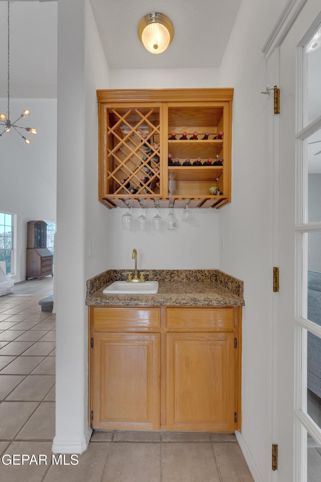 1121 Regal Ridge Dr, El Paso, TX 79912 - indoor wet bar with a chandelier and light tile patterned floors