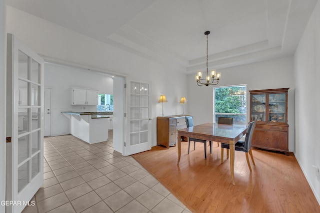 1121 Regal Ridge Dr, El Paso, TX 79912 - dining room with a chandelier, light tile patterned floors, french doors, and a raised ceiling