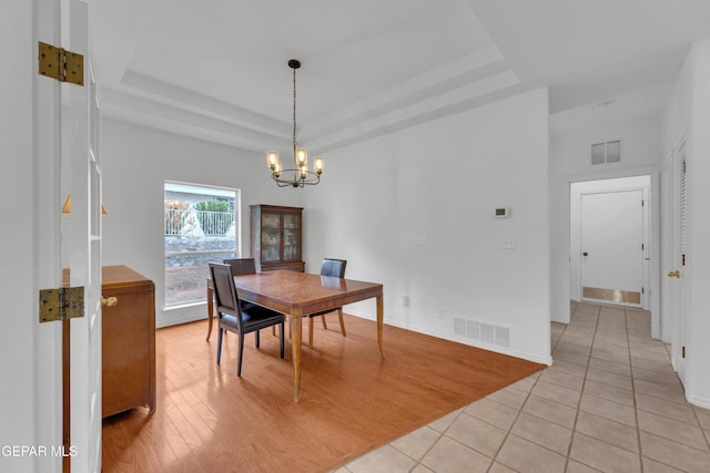 1121 Regal Ridge Dr, El Paso, TX 79912 - dining area with a tray ceiling, a chandelier, and light tile patterned flooring
