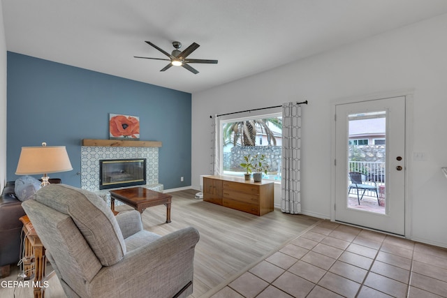 1121 Regal Ridge Dr, El Paso, TX 79912 - living room featuring healthy amount of natural light, a tile fireplace, ceiling fan, and light wood finished floors