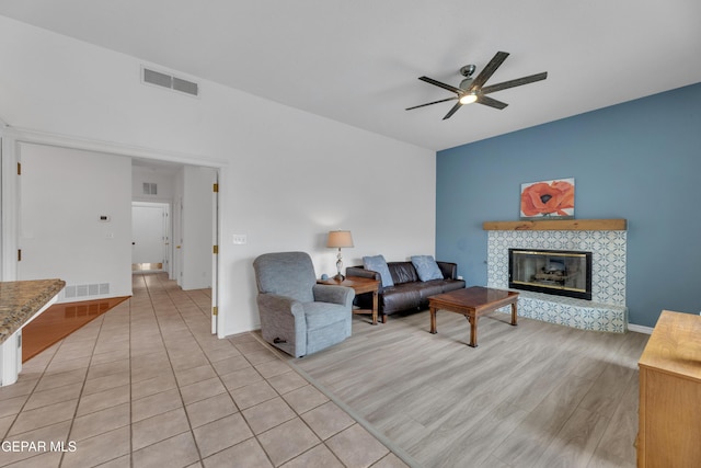 1121 Regal Ridge Dr, El Paso, TX 79912 - living room featuring a ceiling fan, a fireplace, and light wood-style flooring