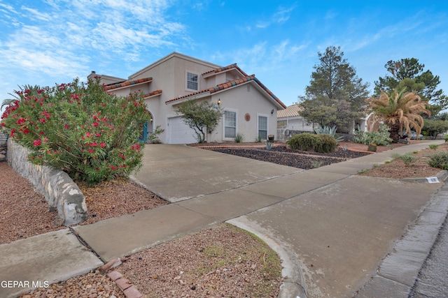 1121 Regal Ridge Dr, El Paso, TX 79912 - mediterranean / spanish house with driveway, stucco siding, a tile roof, and a garage