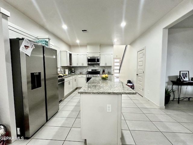 7780 Enchanted Park Dr, El Paso, TX 79911 - kitchen featuring stainless steel appliances, light tile patterned floors, a center island, backsplash, and recessed lighting