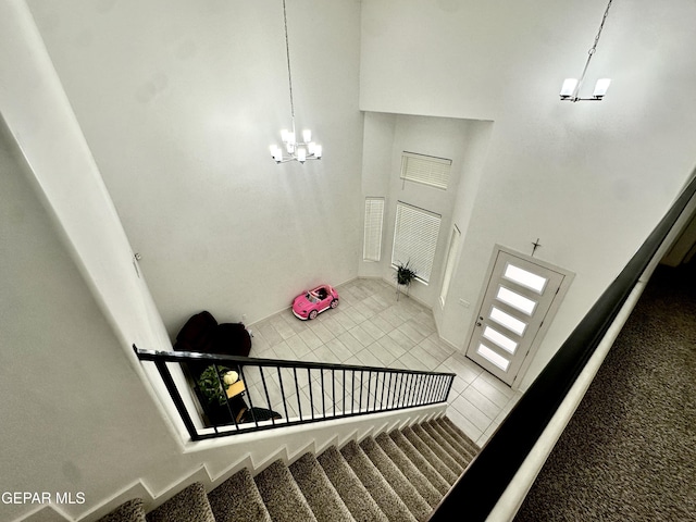 7780 Enchanted Park Dr, El Paso, TX 79911 - stairs featuring a chandelier, tile patterned floors, and a high ceiling