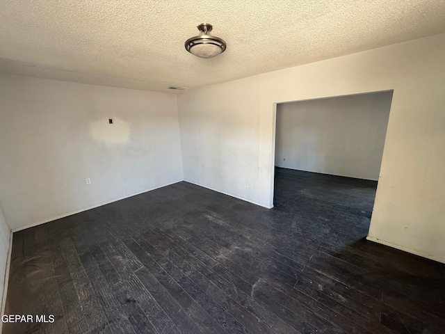 11711 Flor Del Rio St, Socorro, TX 79927 - unfurnished room with dark wood-style floors and a textured ceiling