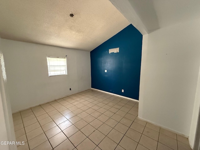 11711 Flor Del Rio St, Socorro, TX 79927 - spare room featuring light tile patterned floors, vaulted ceiling, and a textured ceiling