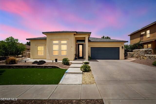 7317 Kiowa Creek Dr, El Paso, TX 79911 - view of front facade with a garage, driveway, and stucco siding