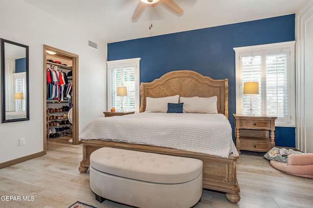 7317 Kiowa Creek Dr, El Paso, TX 79911 - bedroom with a spacious closet, light wood finished floors, and a ceiling fan