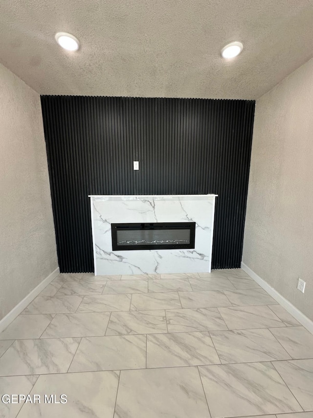 7216 Amethyst Rd, El Paso, TX 79915 - detailed view of a glass covered fireplace, a textured wall, a textured ceiling, and recessed lighting