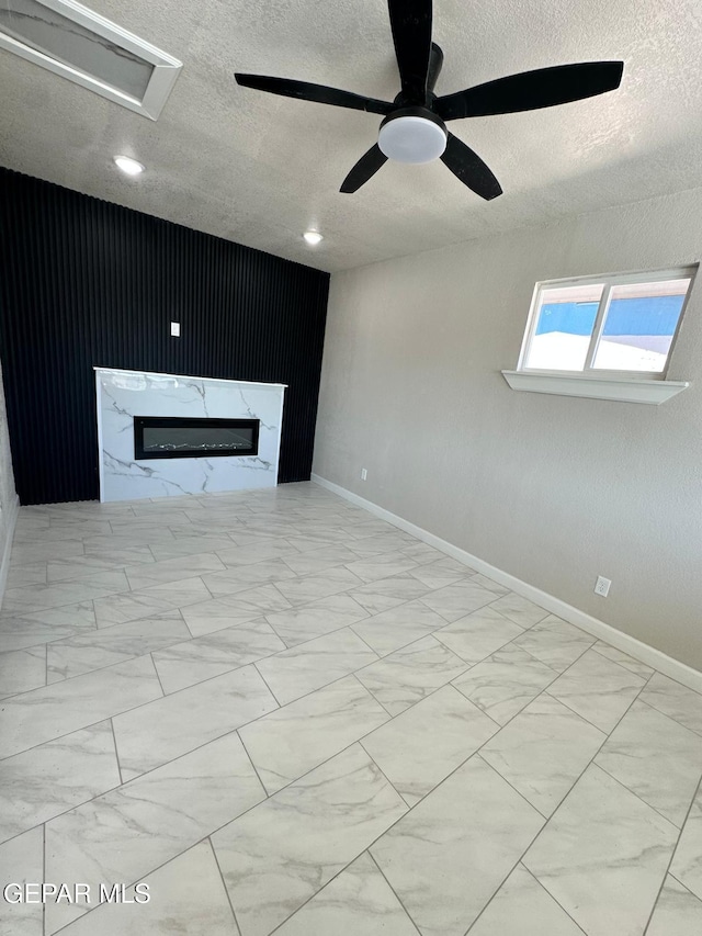 7216 Amethyst Rd, El Paso, TX 79915 - unfurnished living room with a textured ceiling, marble finish floors, a glass covered fireplace, a ceiling fan, and recessed lighting