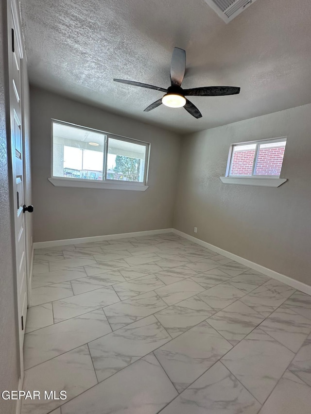 7216 Amethyst Rd, El Paso, TX 79915 - spare room featuring light marble finish floors, ceiling fan, and a textured ceiling
