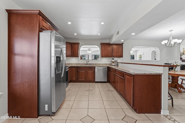 608 Paseo De Luna Ln, El Paso, TX 79912 - kitchen with appliances with stainless steel finishes, a peninsula, recessed lighting, light tile patterned floors, and a breakfast bar