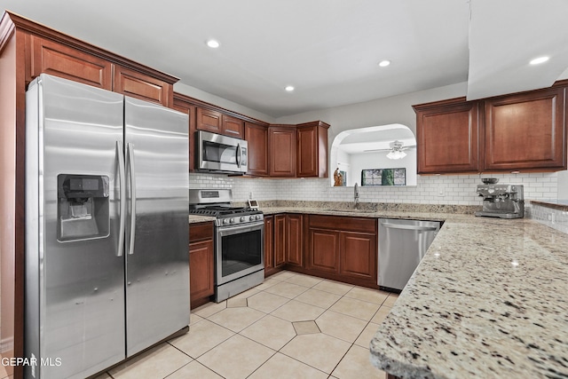 608 Paseo De Luna Ln, El Paso, TX 79912 - kitchen with appliances with stainless steel finishes, tasteful backsplash, recessed lighting, light stone counters, and arched walkways