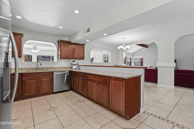 608 Paseo De Luna Ln, El Paso, TX 79912 - kitchen with appliances with stainless steel finishes, a peninsula, arched walkways, open floor plan, and light tile patterned floors
