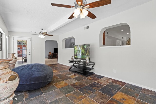 608 Paseo De Luna Ln, El Paso, TX 79912 - living room featuring a ceiling fan, arched walkways, stone tile floors, and a textured ceiling