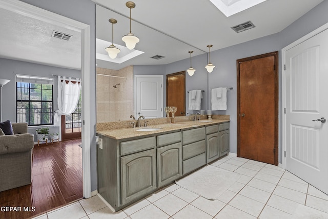 608 Paseo De Luna Ln, El Paso, TX 79912 - bathroom with a skylight, double vanity, tile patterned floors, and a tile shower