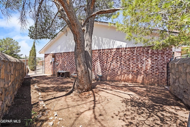 608 Paseo De Luna Ln, El Paso, TX 79912 - view of property exterior featuring brick siding and a gate