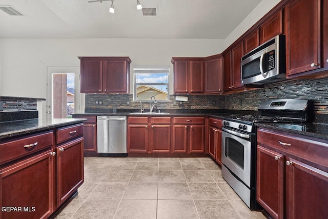 5020 Copper Ranch Ave, El Paso, TX 79934 - kitchen featuring stainless steel appliances, dark brown cabinets, backsplash, and dark stone countertops
