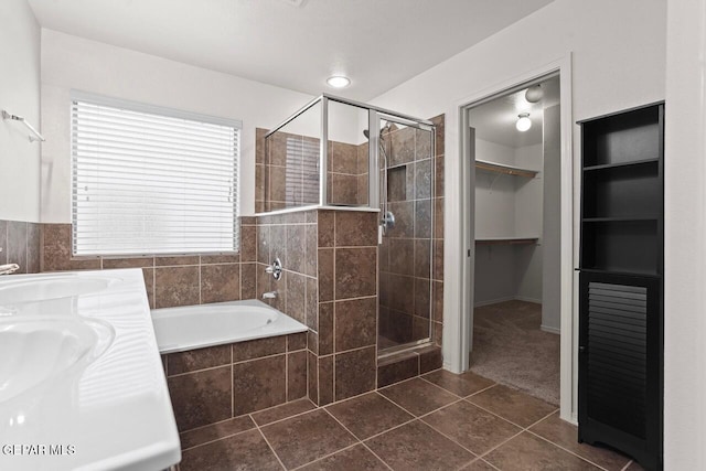 5020 Copper Ranch Ave, El Paso, TX 79934 - full bathroom featuring a shower stall, tile patterned floors, tiled tub, and a walk in closet