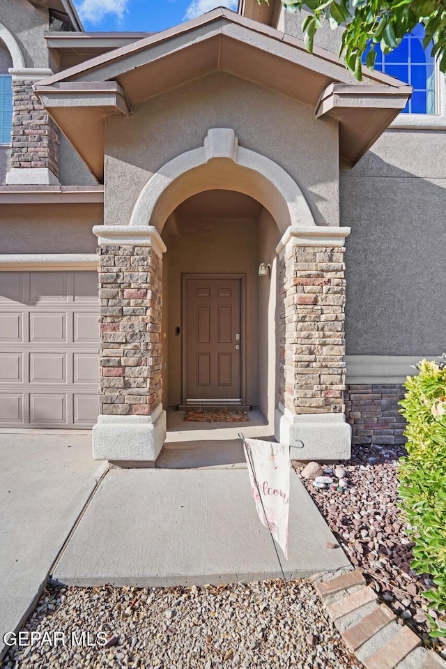 5020 Copper Ranch Ave, El Paso, TX 79934 - property entrance with stone siding, stucco siding, a garage, and concrete driveway