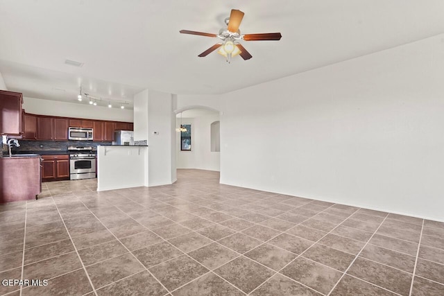 5020 Copper Ranch Ave, El Paso, TX 79934 - unfurnished living room with ceiling fan, arched walkways, light tile patterned floors, and rail lighting