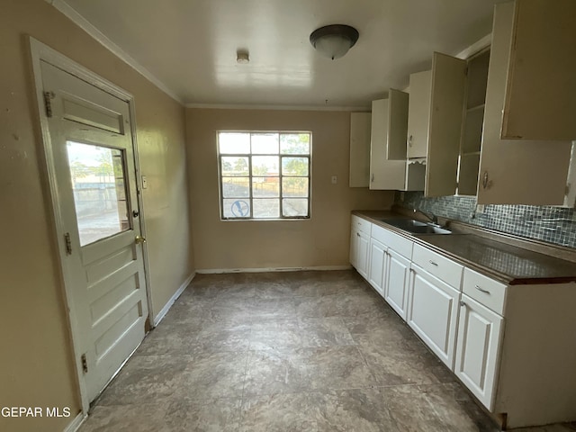 320 Edith Dr, El Paso, TX 79915 - kitchen featuring dark countertops, decorative backsplash, ornamental molding, and white cabinetry
