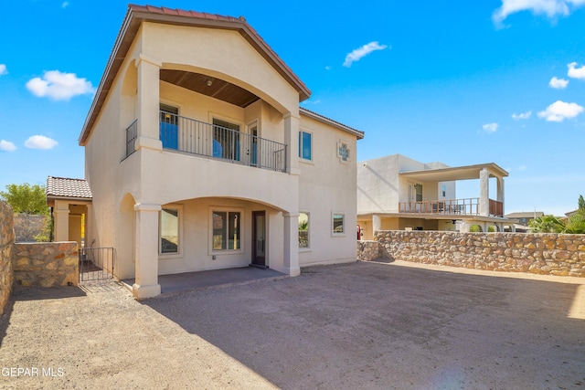 545 Lanner Dr, El Paso, TX 79928 - rear view of property with a balcony, stucco siding, a gate, and a tiled roof