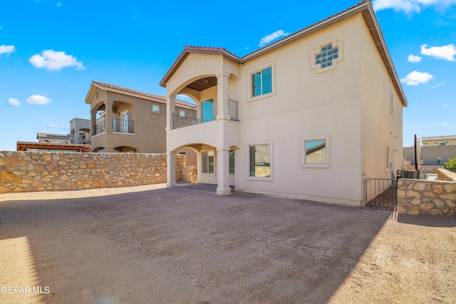 545 Lanner Dr, El Paso, TX 79928 - back of house featuring stucco siding, a gate, a balcony, and a tile roof