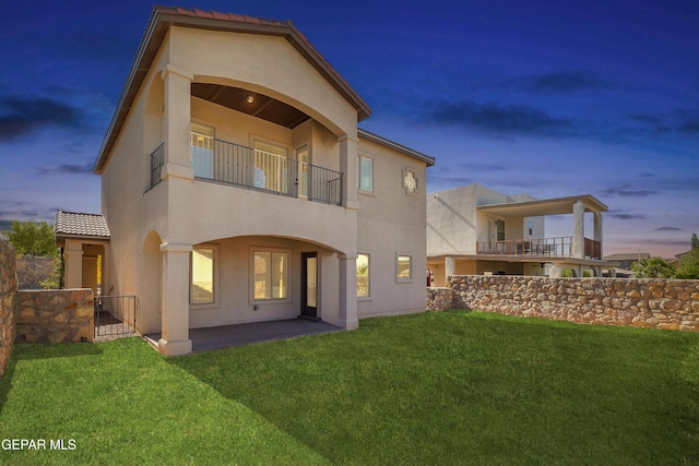 545 Lanner Dr, El Paso, TX 79928 - back of property at dusk featuring a balcony, stucco siding, and a patio area