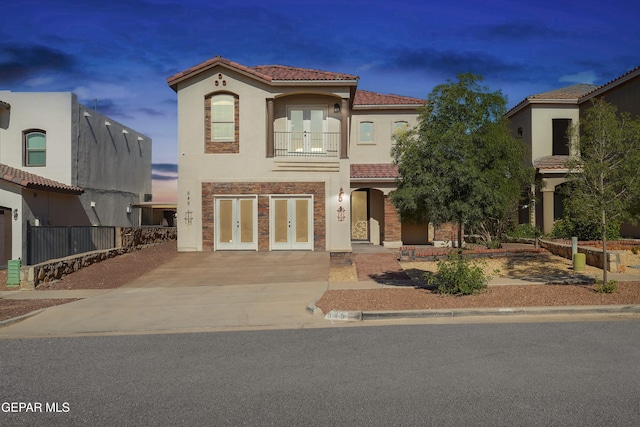 545 Lanner Dr, El Paso, TX 79928 - mediterranean / spanish house with french doors, a tiled roof, stucco siding, a balcony, and driveway