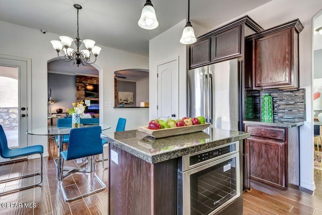 545 Lanner Dr, El Paso, TX 79928 - kitchen featuring arched walkways, dark countertops, freestanding refrigerator, and light wood-type flooring