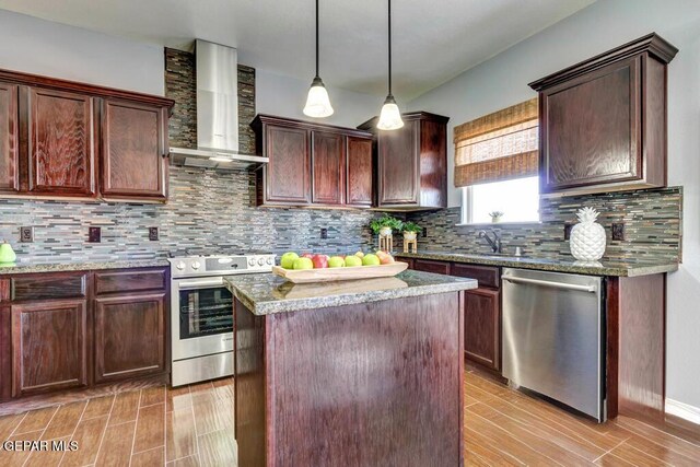 545 Lanner Dr, El Paso, TX 79928 - kitchen featuring stainless steel appliances, wall chimney exhaust hood, a center island, tasteful backsplash, and light wood finished floors