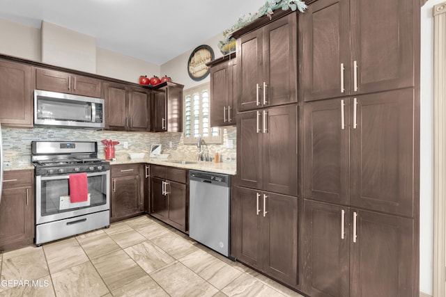 14192 Earl Chokiski, El Paso, TX 79938 - kitchen featuring appliances with stainless steel finishes, tasteful backsplash, light stone counters, dark brown cabinetry, and light marble finish flooring