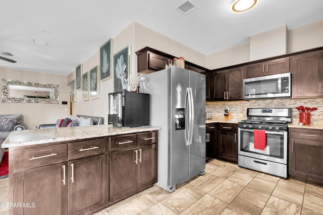 14192 Earl Chokiski, El Paso, TX 79938 - kitchen with stainless steel appliances, open floor plan, a peninsula, dark brown cabinetry, and tasteful backsplash