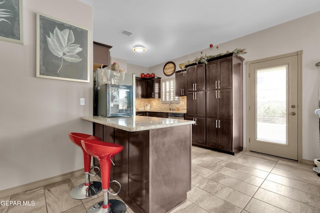 14192 Earl Chokiski, El Paso, TX 79938 - kitchen with fridge, a peninsula, dark brown cabinets, and plenty of natural light