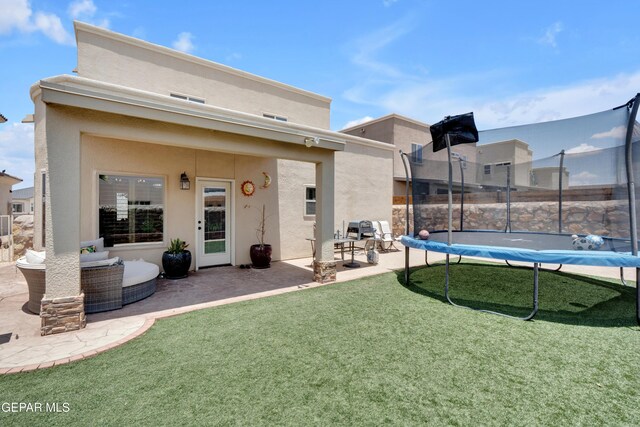 14192 Earl Chokiski, El Paso, TX 79938 - back of property with a patio area, stucco siding, a lawn, and a trampoline