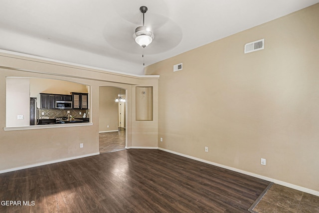 5024 Gold Ranch Ave, El Paso, TX 79934 - unfurnished living room with a ceiling fan, dark wood-style flooring, and arched walkways
