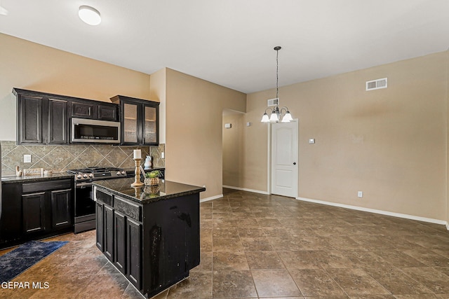 5024 Gold Ranch Ave, El Paso, TX 79934 - kitchen featuring stainless steel appliances, dark cabinets, tasteful backsplash, a chandelier, and stone finish flooring