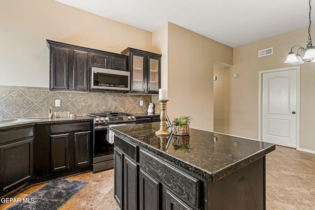 5024 Gold Ranch Ave, El Paso, TX 79934 - kitchen featuring stainless steel appliances, tasteful backsplash, a chandelier, dark stone counters, and hanging light fixtures