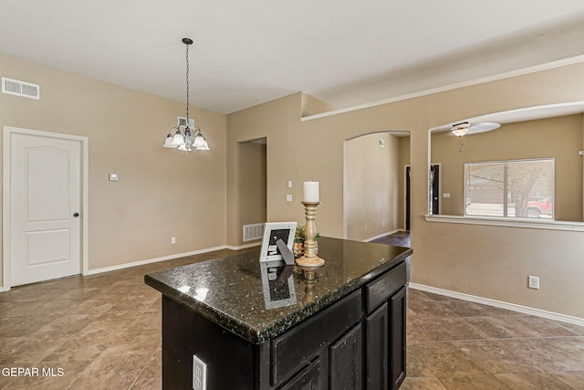 5024 Gold Ranch Ave, El Paso, TX 79934 - kitchen featuring dark cabinetry, a chandelier, pendant lighting, dark stone countertops, and a kitchen island