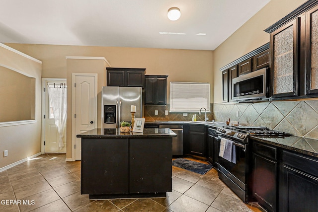 5024 Gold Ranch Ave, El Paso, TX 79934 - kitchen with stainless steel appliances, a kitchen island, decorative backsplash, dark tile patterned floors, and dark stone countertops