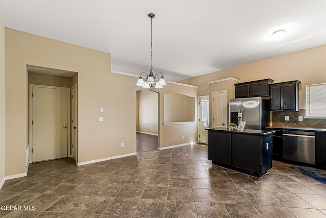 5024 Gold Ranch Ave, El Paso, TX 79934 - kitchen with appliances with stainless steel finishes, dark countertops, a chandelier, a center island, and backsplash
