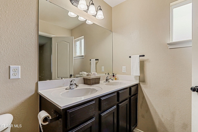 5024 Gold Ranch Ave, El Paso, TX 79934 - bathroom featuring double vanity and a textured wall