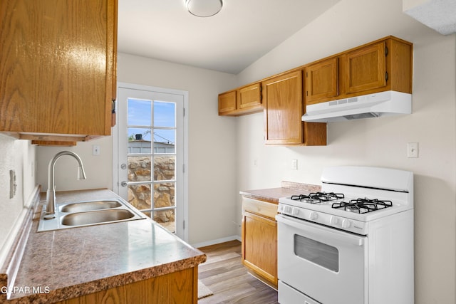 10980 Northampton St, El Paso, TX 79934 - kitchen with gas range gas stove, under cabinet range hood, light wood-style flooring, light countertops, and lofted ceiling