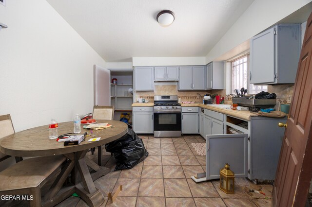 123 Marquita Ln, El Paso, TX 79915 - kitchen featuring stainless steel range with gas cooktop, gray cabinetry, decorative backsplash, light countertops, and light tile patterned flooring